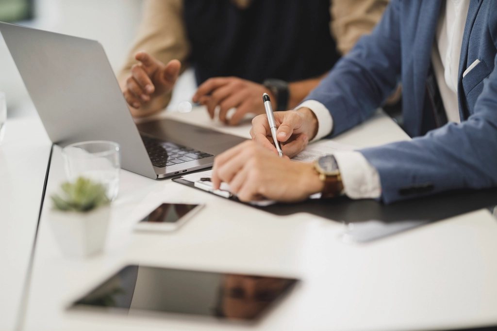 Un consultant et sa cliente revèrent un dossier autour d'une table